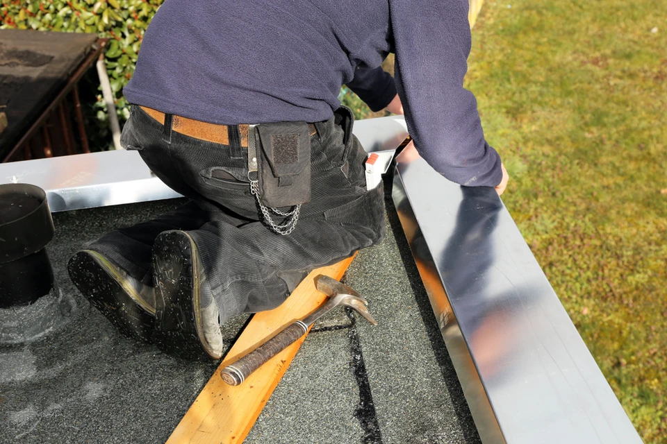 Photographie montrant un professionnel du bâtiment inspectant un mur humide avec des traces d'infiltration, utilisant un détecteur d'humidité portable. L'arrière-plan doit montrer d'autres éléments de rénovation ou intervention (échafaudage, outils variés) pour évoquer la multiplicité des interventions. La scène doit se dérouler en intérieur, dans un contexte de diagnostic de problème d'humidité/infiltration, illustrant ainsi le début du processus global de prise en charge du Groupe SARI (détection → assèchement → réparation → rénovation).