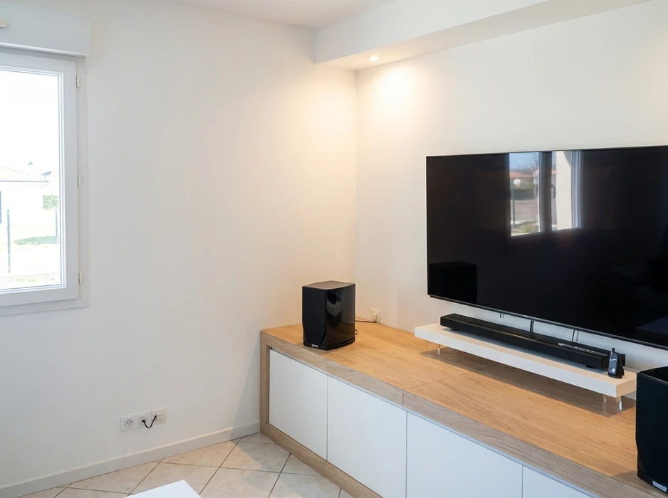 Intérieur en cours de rénovation avec mur bleu, parquet bois et équipements de peinture disposés au sol